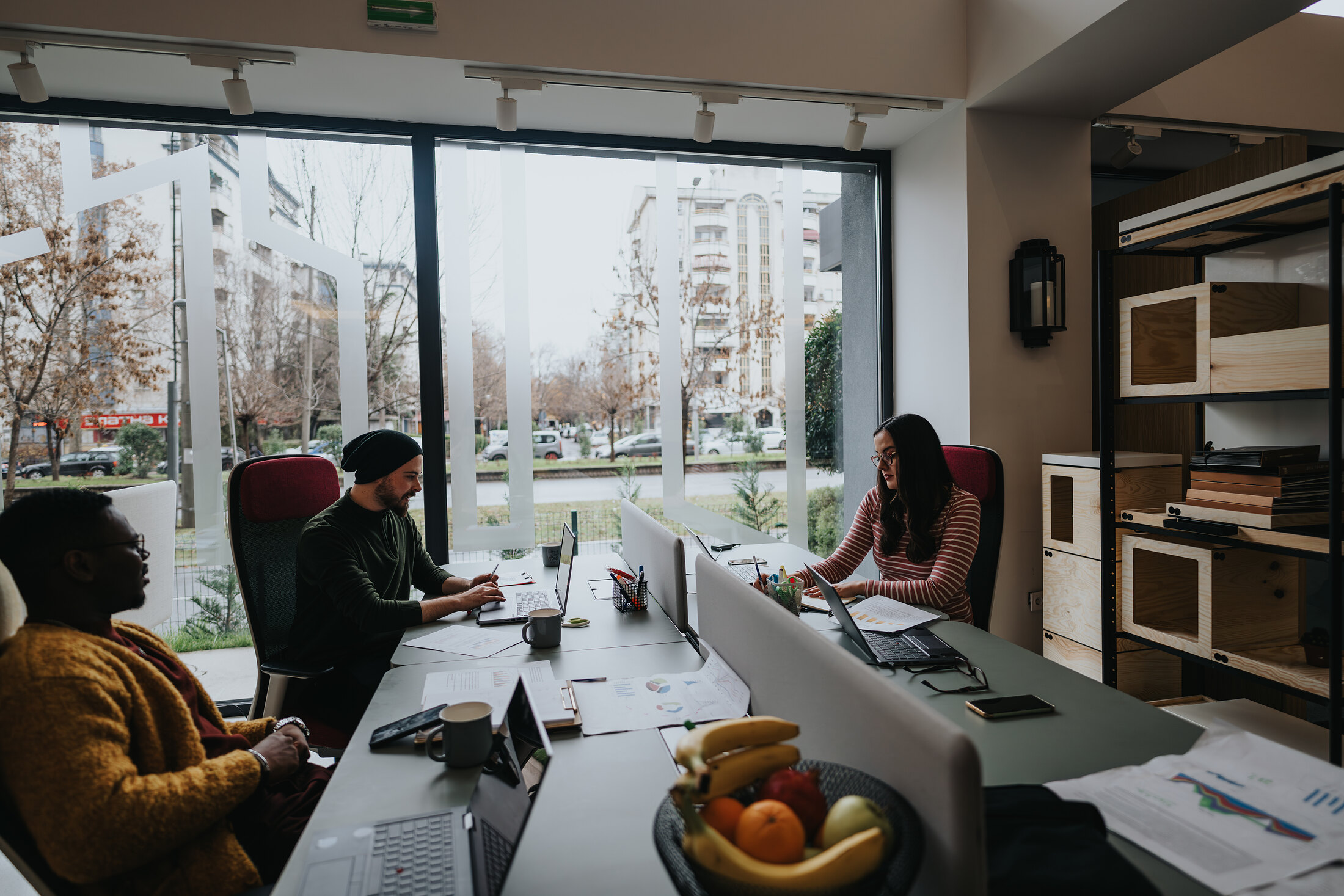 A small team working side by side in a sunlit office.