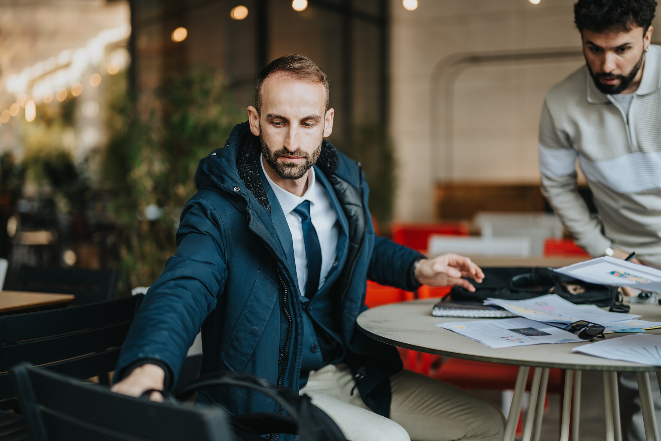 Two people working a bid together over coffee.